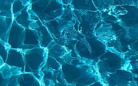 Klares Wasser mit Lichtreflexionen Nahaufnahme von Wasseroberfläche mit Lichtspiel und Wellen.