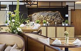 Modernes Restaurant mit gedeckten Tischen, Blumenarrangements und warmer Beleuchtung.